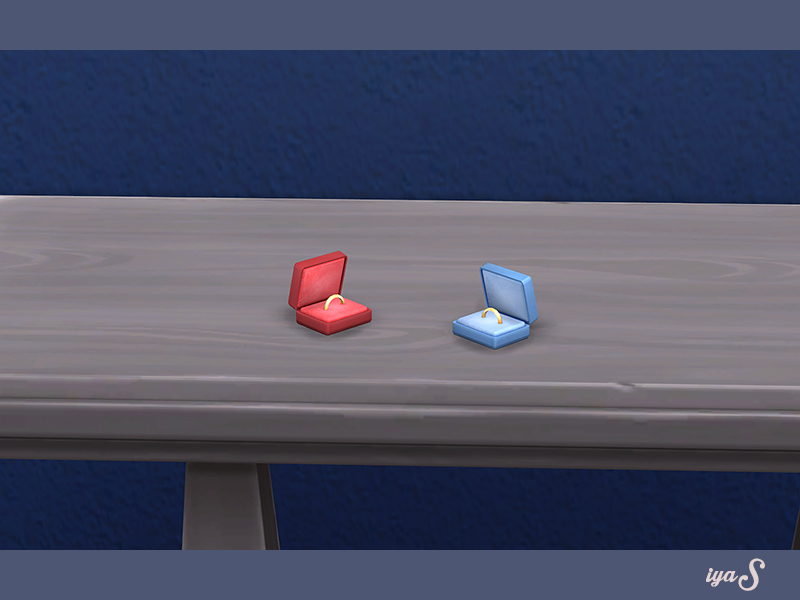 Ein Tisch aus hellem Holz mit zwei kleinen Ringboxen, eine rot und eine blau.